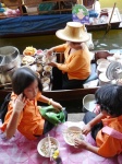 niñas comiendo de un puesto del mercado flotante
tailandia