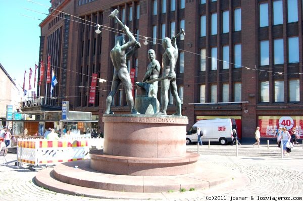 Los Tres Herreros. Helsinki
Estatua realista de bronce sobre pedestal de granito rojo, situada en la Plaza Erotajja(comienzo de zona comercial hasta final de Esplanadi), es un simbolo del trabajo humano y cooperación entre las personas, el herrero que levanta el martillo es autoretrato del autor Félix Nylund
