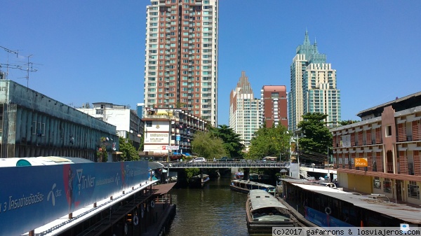 barcas, barcas taxi,
barcas, ó barcas-bus, por los canales de Bangkok, entre edificios
