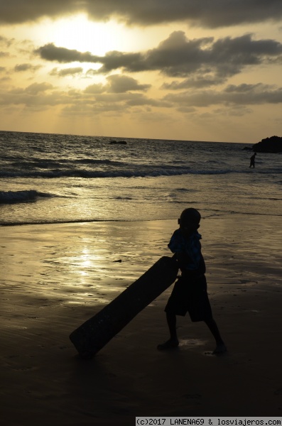 NIÑO JUGANDO CON UN TRONCO EN LA PLAYA
