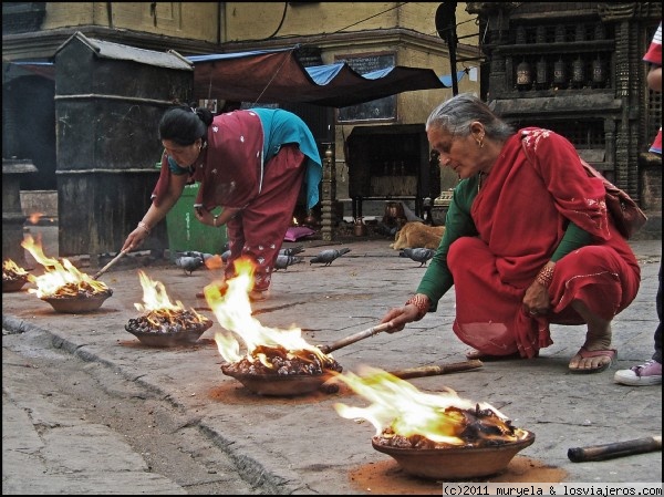 Ofrendas
Dos mujeres encendiendo fuegos alrededor de una stupa como ofrenda en Kathmandu, Nepal
